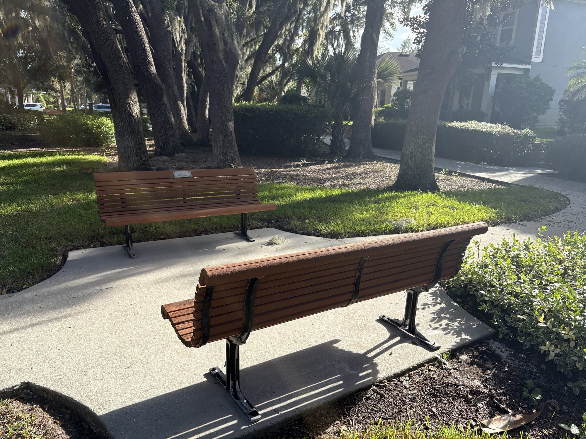 The bench on its concrete pad, with the second bench across the lawn behind it.