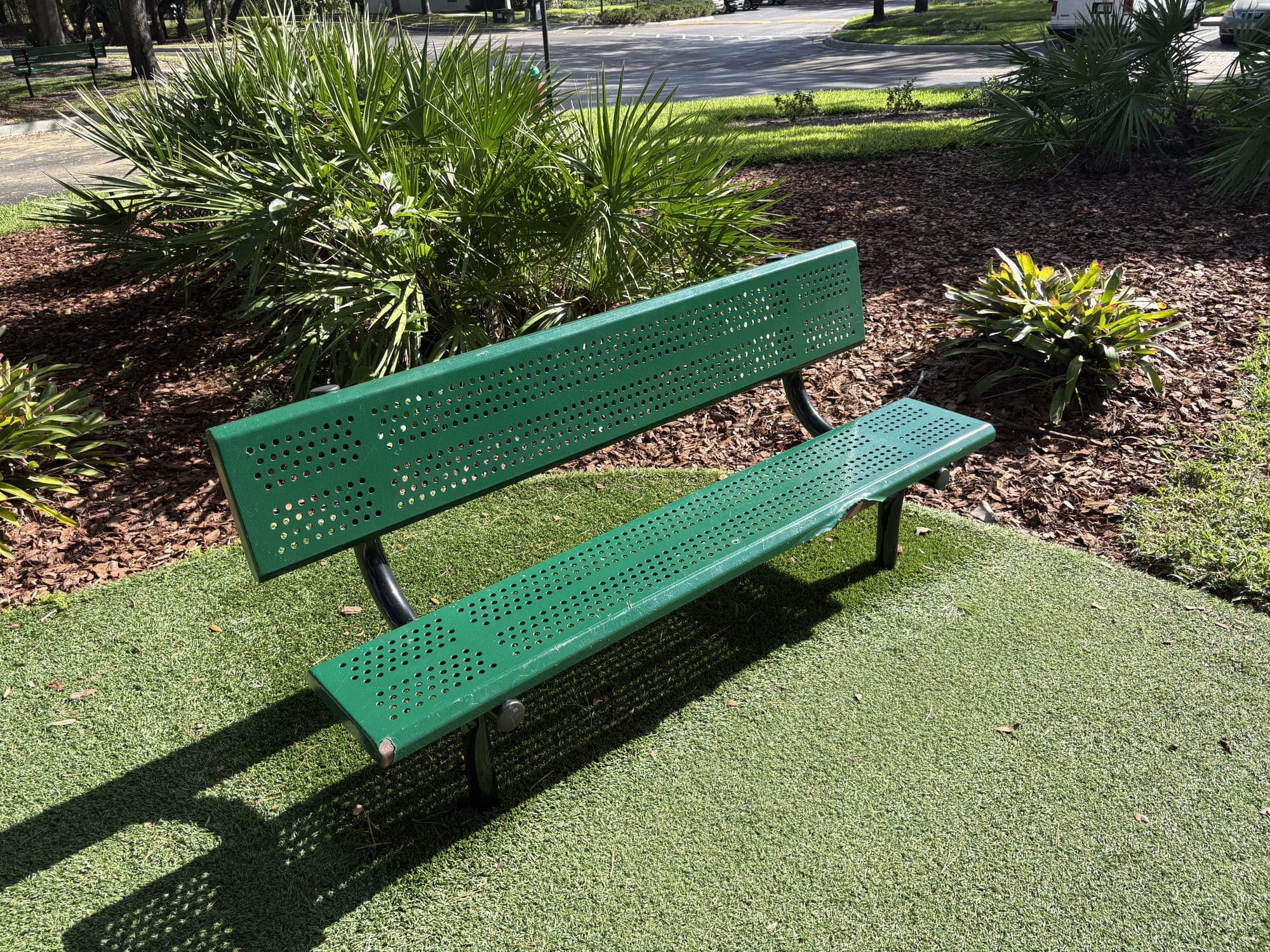 The second bench beside it, with palms and the street beyond.