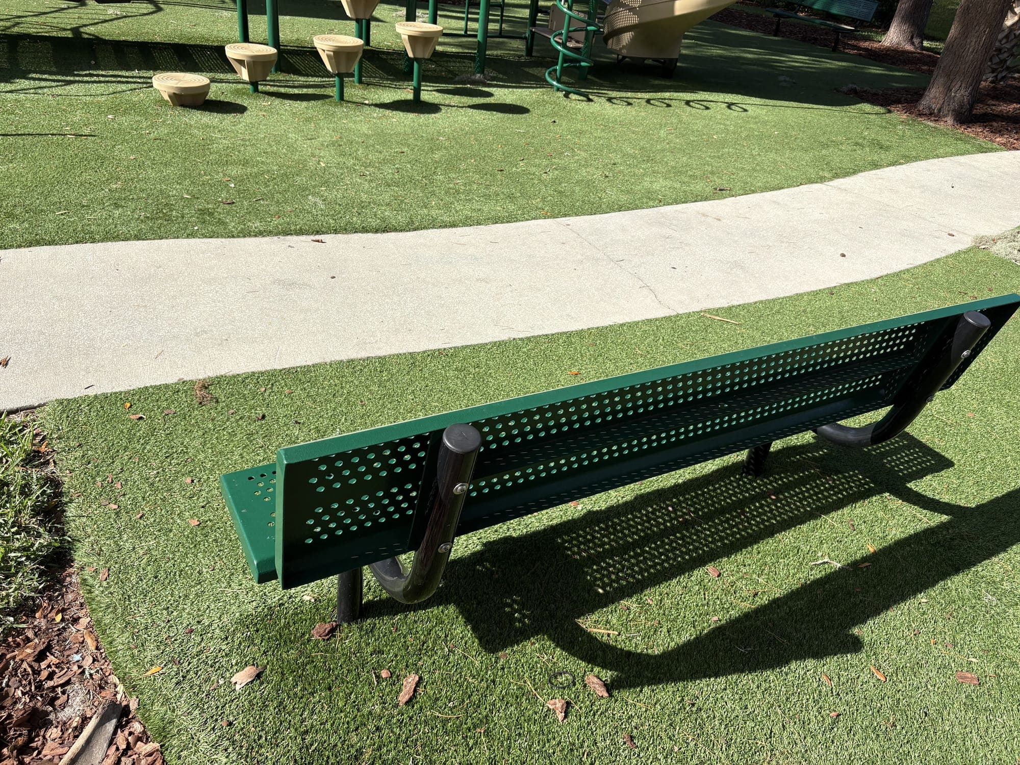 The second bench from behind, facing the playground.